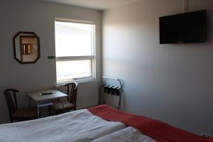 - une chambre avec un lit, une table et une fenêtre dans l'établissement Sunnuberg Guesthouse, à Hofsós