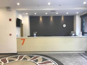 a lobby with a cash counter and a large wall at 7Days Premium Xichang Torch Plaza Qionghai Wetland Park Branch in Xichang