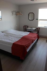 
a bedroom with a bed and a desk at Sunnuberg Guesthouse in Hofsós
