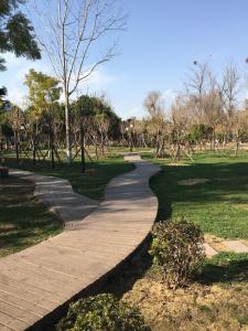 a path in a park with trees and grass at 7Days Premium Xichang Torch Plaza Qionghai Wetland Park Branch in Xichang