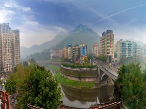 eine Stadt mit einer Brücke über einen Fluss und Gebäuden in der Unterkunft 7Days Premium Nanchong Silk Road Branch in Nanchong