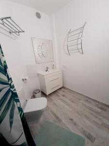 a bathroom with a toilet and drawings on the wall at Finca La Barca in El Médano