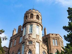 an old building with a tower on top of it at 7Days Premium Qingdao Technology Street Branch in Qingdao