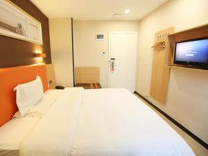 a hotel room with a bed and a flat screen tv at 7Days Premium Changsha Hongxing South Bus Station Branch in Changsha