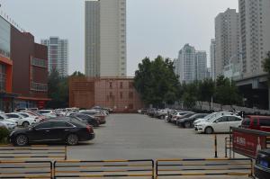 un estacionamiento lleno de coches en una ciudad en 7Days Premium Shijiazhuang Zhonghua Avenue North 2nd Ring Mingyue Jiaju Branch en Shijiazhuang