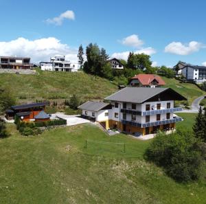 eine Luftansicht eines Hauses auf einem Hügel in der Unterkunft Ferienwohnungen Pirker in Drobollach am Faakersee