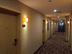a hallway of a hotel with a long corridor at 7Days Premium Xingtai Zhongxing West Street Gushun Branch in Xingtai