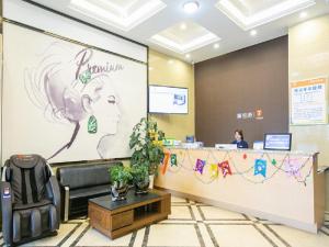 a woman sitting at a reception desk in a lobby at 7Days Premium Chongqing West Station Branch in Chongqing
