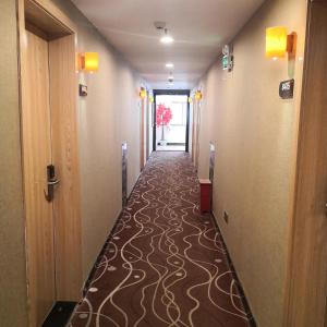 a hallway with a long hallway with a carpeted floor at 7Days Premium Ji'an Taihe Gongnongbing Avenue Branch in Ji'an