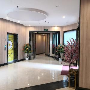 a lobby of a building with a hallway with flowers at 7Days Premium Ji'an Taihe Gongnongbing Avenue Branch in Ji'an