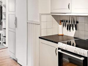 a kitchen with white cabinets and a stove top oven at 10 person holiday home in S LEN in Sälen