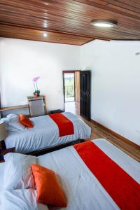 a bedroom with two beds with red and white sheets at Mar Inn Costa Rica in Monteverde Costa Rica