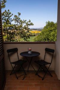 d'une petite table et de deux chaises sur un balcon. dans l'établissement Hotel Ristorante Farneta, à Cortone