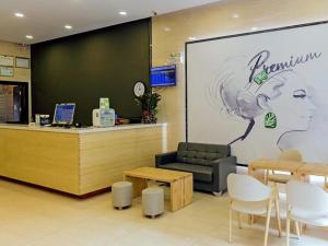 a waiting area of a store with a large screen with a woman at 7Days Premium Xiamen Airport Xianglu Branch in Xiamen