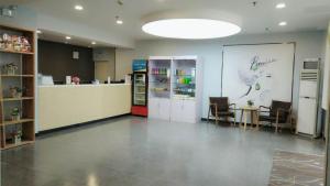 a large room with a counter and chairs in a store at 7Days Premium Qingdao Xianggang Middle Road Zhiqun Road Subway Station Branch in Qingdao