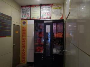 una máquina expendedora en un edificio con carteles en la pared en 7Days Premium Zunyi Dingzikou Branch, en Zunyi