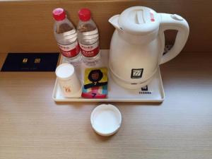 a tray with a tea kettle and condiments on a table at 7Days Premium Zunyi Dingzikou Branch in Zunyi