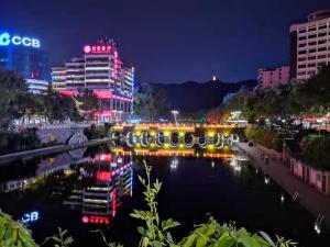 a river in a city at night with buildings at 7Days Premium Zunyi Dingzikou Branch in Zunyi