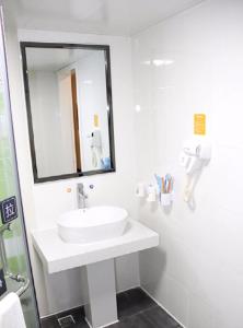 海口市にある7Days Premium Haikou Pearl Plaza Wuzhishan Road Branchの洗面台と鏡のある白いバスルーム