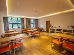 una classe con tavoli e sedie in una stanza di 7 Days Premium Zhaotong Zhenxiong Branch a Zhenxiong