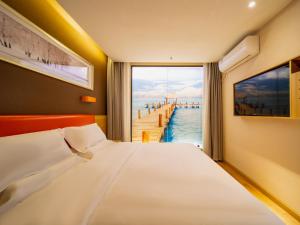 a bedroom with a bed and a view of a pier at 7 Days Premium Zhaotong Zhenxiong Branch in Zhenxiong