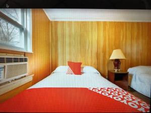 a bedroom with a bed with a red and white blanket at Monmouth OYO in Neptune City