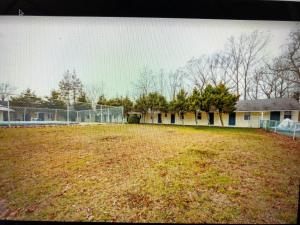 a soccer field with a fence in front of a house at Monmouth OYO in Neptune City