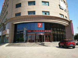 un edificio con un coche aparcado delante de él en 7Days Premium Shandan Center Plaza Branch en Zhangye