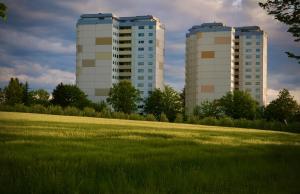 two tall buildings in a field next to a field of grass at Gemütliches Studio für zwei in Immenstaad nur 500m vom See in Immenstaad am Bodensee