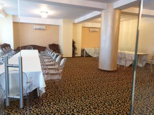 einen Bankettsaal mit Tischen und Stühlen und einer Säule in der Unterkunft Hotel Magic - City Center in Piteşti
