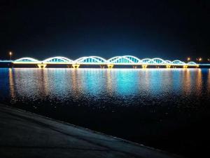 uma ponte sobre um corpo de água à noite em 7Days Premium Bole Tuanjie South Road Lanhu Courtyard Branch em Dalt