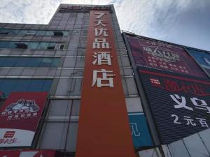 een hoog gebouw met borden aan de zijkant bij 7Days Premium Yantai Railway Station Branch in Yantai