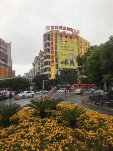 un gran edificio amarillo con un cartel en una ciudad en 7 Days Premium Yichun Gaoshi Road Branch, en Yichun