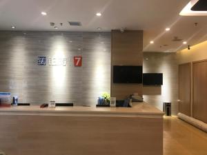 a lobby with a reception desk with a sign on the wall at 7 Days Premium Yichun Gaoshi Road Branch in Yichun
