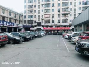 un estacionamiento con autos estacionados frente a edificios altos en 7 Days Premium Yichun Gaoshi Road Branch, en Yichun