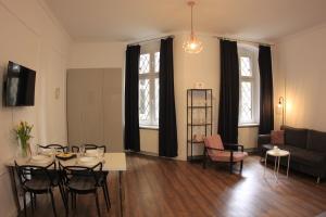 a living room with a table and chairs and a couch at Centrum Starówki Szeroka Komfort by Rentoom in Toruń
