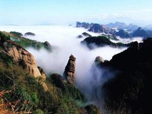 een uitzicht op een bergvallei met wolken en rotsen bij 7Days Premium Longyan Liancheng Guanzhi Mountain Scenic Spot Branch in Wenheng