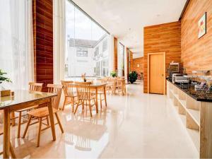 - une cuisine et une salle à manger avec des tables et des chaises en bois dans l'établissement 7Days Premium Longyan Liancheng Guanzhi Mountain Scenic Spot Branch, à Wenheng