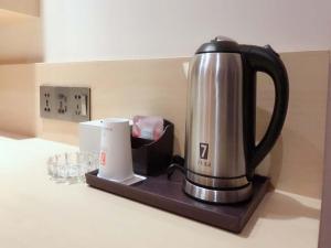 a coffee maker sitting on a counter next to glasses at 7Days Premium Dezhou University South Gate Branch in Dezhou