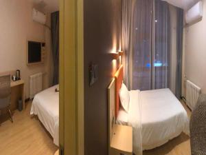Un pat sau paturi într-o cameră la 7Days Premium Dezhou University South Gate Branch