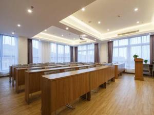 una grande stanza con una fila di tavoli e panche di 7Days Premium Chongqing Liangping People's Square Center Branch a Liangping