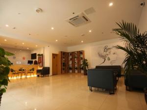 a living room with a table and a painting on the wall at 7Days Premium Hengshui Shenzhou City Government Branch in Hengshui