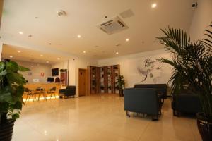 a living room with a table and a painting on the wall at 7Days Premium Hengshui Shenzhou City Government Branch in Hengshui +3 photos