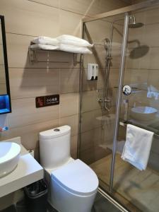 a bathroom with a toilet and a glass shower at 7Days Premium Hengshui Shenzhou City Government Branch in Hengshui