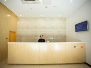 a woman sitting at a counter in an office at 7Days Premium Beijing International Trade Jinsong Subway Station Branch in Beijing