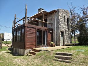 une maison assise dans l'herbe dans l'établissement Piedra y Cielo, à Punta del Diablo