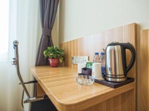 a wooden counter with a coffee maker on it at 7Days Premium Luoyang Yichuan Dukang Avenue Branch in Luoyang