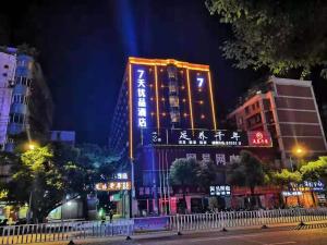 a building with lit up signs in a city at night at 7Days Premium Ganzhou Bus Station Branch in Ganzhou