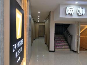 a hallway with a staircase in a building with a sign at 7Days Premium Xining Bayi East Road Tuanjie Bridge Branch in Xining
