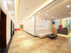 een woonkamer met een bank en een tafel bij 7Days Premium Jinan Beiyuan Street Red Star Macalline Branch in Jinan
